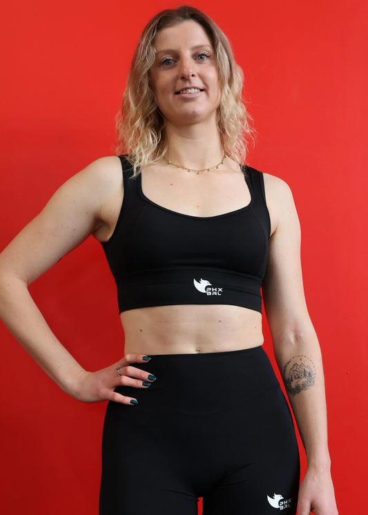 Brassière femme DOMINA Phoenix Barbell portée, vue face avec logo poitrine