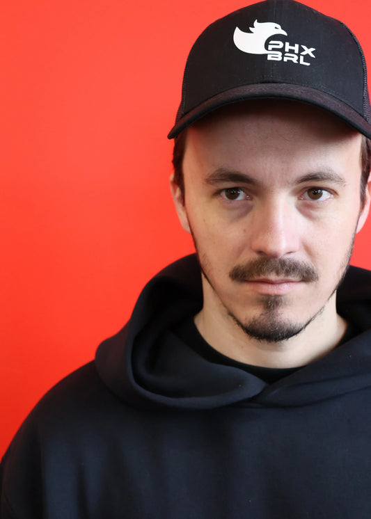 Casquette DAEMON Phoenix Barbell curve trucker noire portée, vue face avec logo brodé blanc