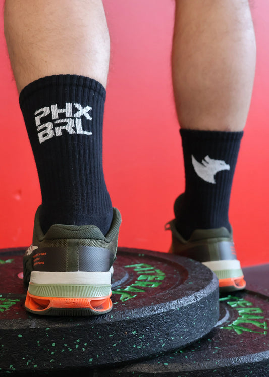 Chaussettes PYROS Phoenix Barbell noires portées logo PHX BRL maintien mollet